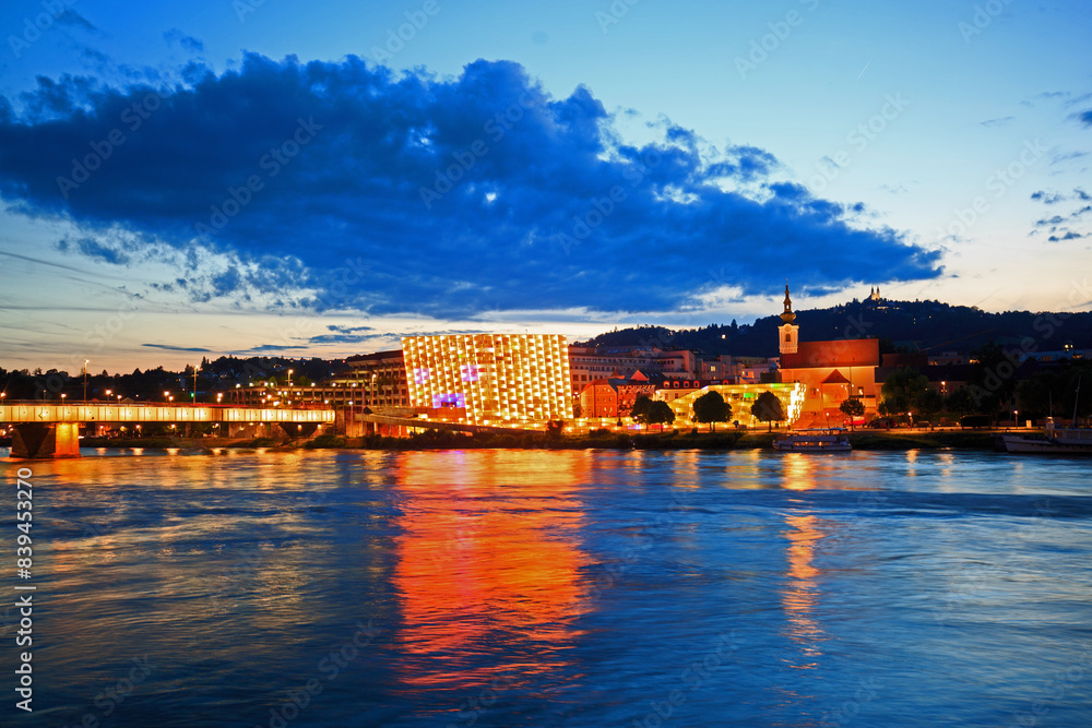 Fototapeta premium Vienna on the River Danube with illuminated buildings reflecting in the water