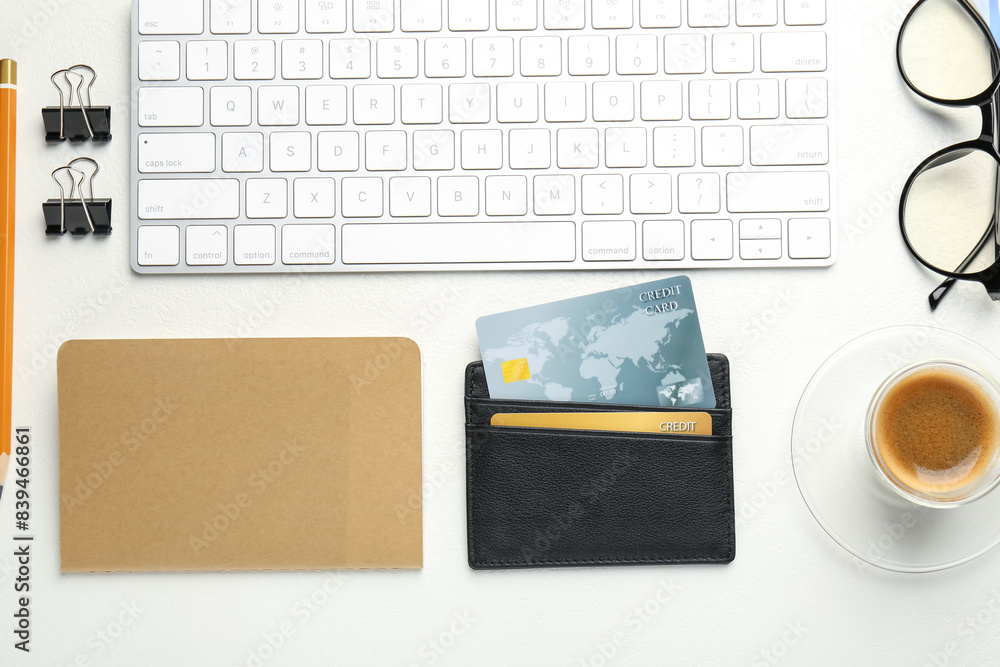 Leather card holder with credit cards, glasses, keyboard, coffee and stationery on white table, flat lay Leather card holder with credit cards, glasses, keyboard, coffee and stationery on white table, flat lay