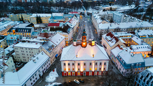 This is Tartu Estonia, a night aerial view of the city center, the medieval buildings are covered with snow and it looks like a charming Christmas village.