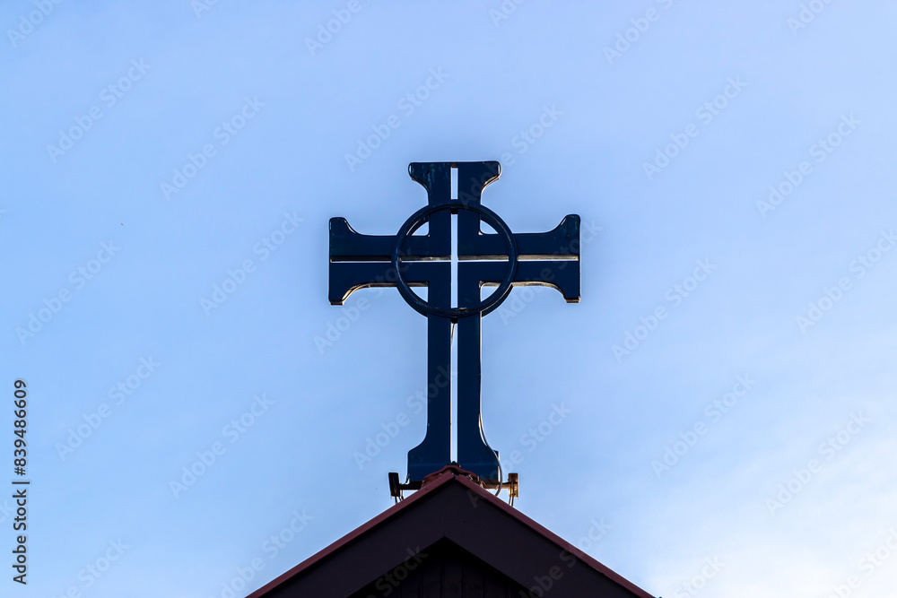 Crucifix on top tower of chapel in Brazil, with blue sky background Crucifix on top tower of chapel in Brazil, with blue sky background