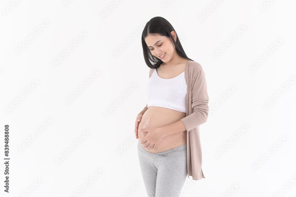Beautiful pregnant woman applying moisturizing, stretch mark cream on belly, fertility infertility treatment, IVF, future maternity concept Beautiful pregnant woman applying moisturizing, stretch mark cream on belly, fertility infertility treatment, IVF, future maternity concept