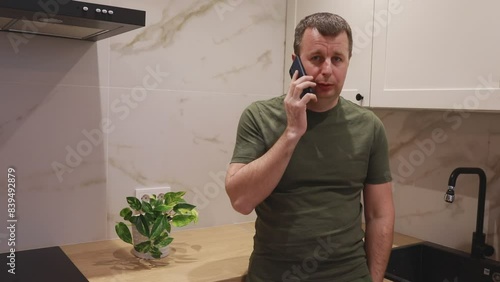 Man Talking on Cell Phone in Kitchen