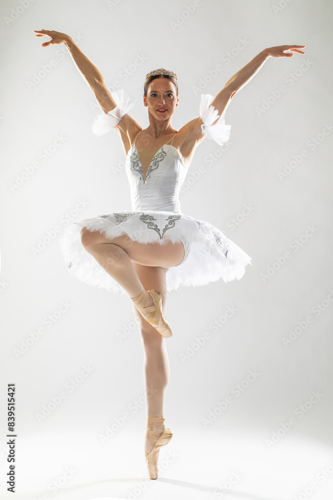Full length portrait of an adult female ballerina in a white tutu Full length portrait of an adult female ballerina in a white tutu