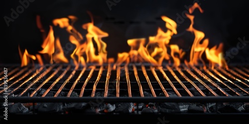 Hot empty portable barbecue BBQ grill with flaming fire and ember charcoal on black background