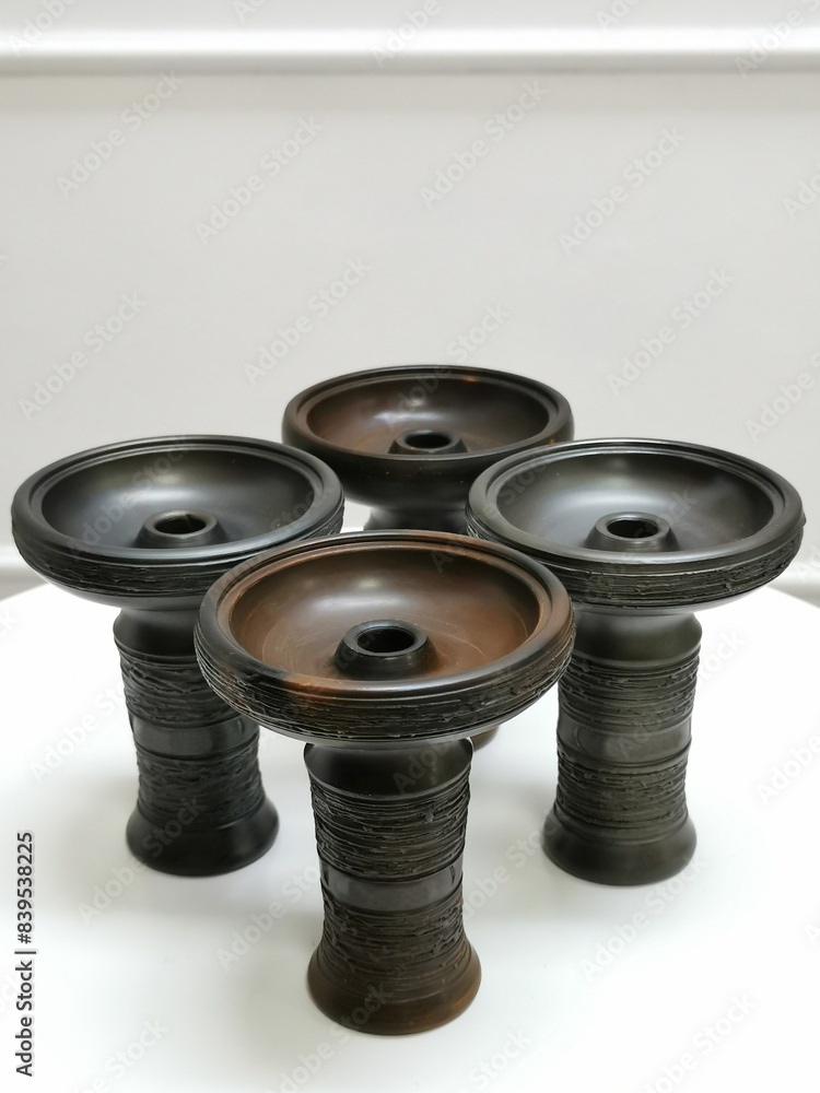 Four Ceramic Hookah Bowls Standing in a Row Against a White Background Four Ceramic Hookah Bowls Standing in a Row Against a White Background