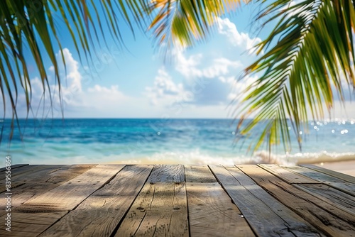 Empty wood table over blue sea, beach and palm leaves background in summer day.