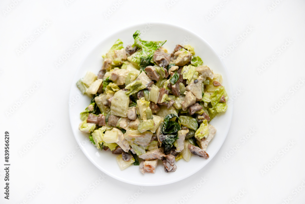 Salad with herbs and meat on a white plate. Delicious salad with mayonnaise and mushrooms. Salad with herbs and meat on a white plate. Delicious salad with mayonnaise and mushrooms.