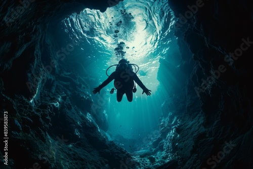 A diver diving in the deep blue sea exploring an underwater cave 