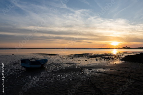 Barque sur la plage au coucher du soleil