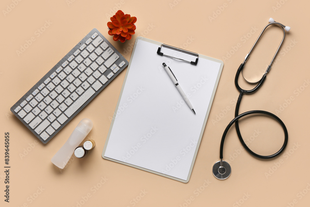 Modern computer keyboard, pen, clipboard and stethoscope on beige background Modern computer keyboard, pen, clipboard and stethoscope on beige background