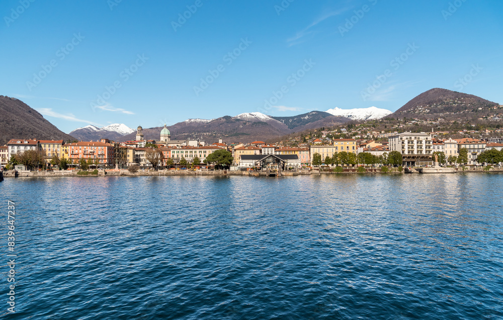 Panoramic view of the Intra town from Lake Maggiore with snow-capped mountains in the background, Verbania, Piedmont, Italy Panoramic view of the Intra town from Lake Maggiore with snow-capped mountains in the background, Verbania, Piedmont, Italy