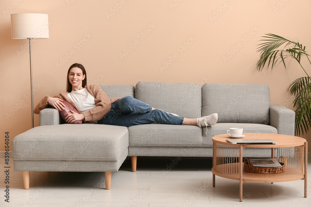 Obraz premium Young woman lying on sofa in stylish living room
