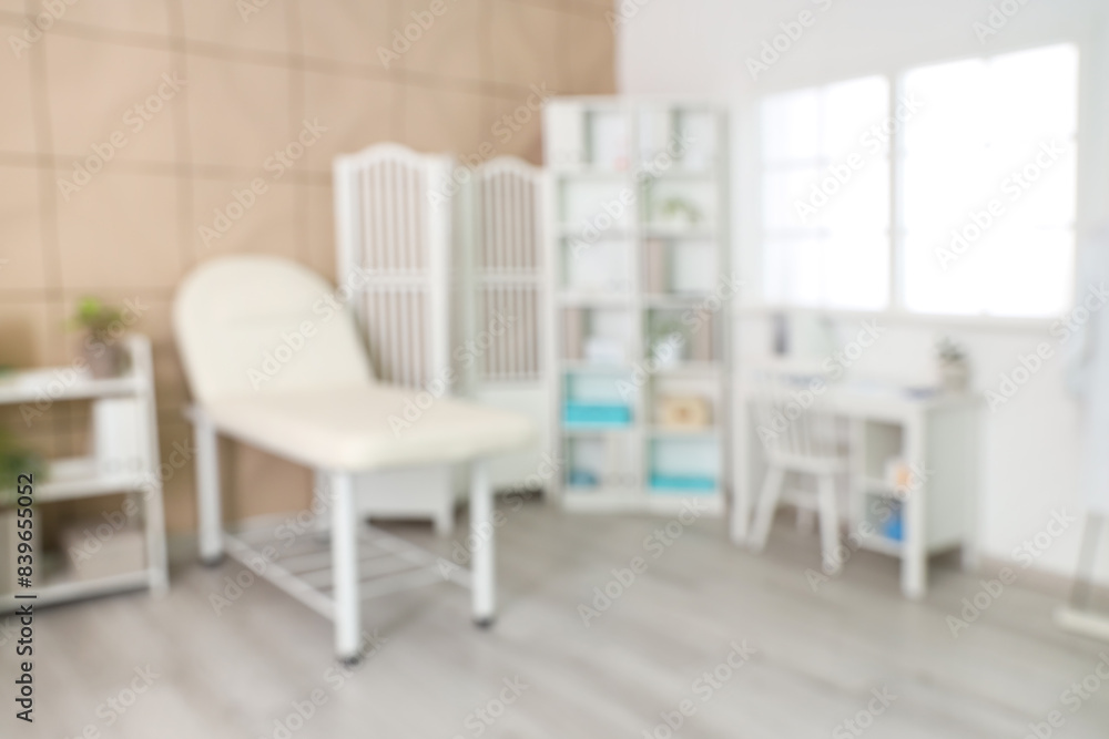 Blurred view of medical office with couch, shelf units and doctor's workplace Blurred view of medical office with couch, shelf units and doctor's workplace