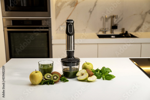 Konstfotografi Electric immersion blender with smoothies and green fruits on the kitchen table
