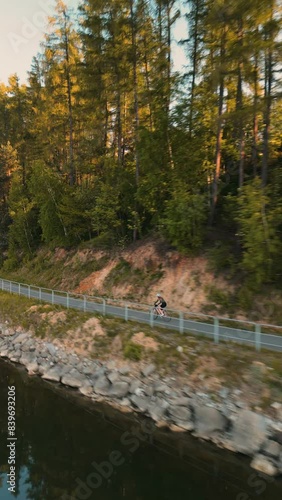 Aerial footage of a drone. Girl riding a bike on the road photo