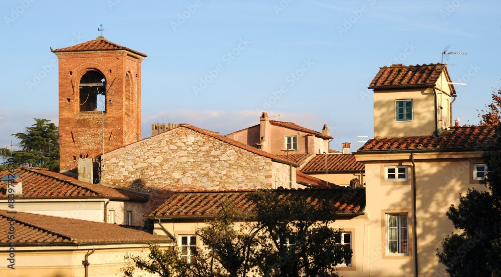 Lucca, antica torre del mattone e tetti di vecchie case, Toscana, Italia