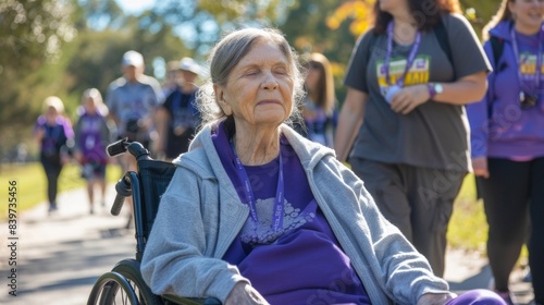 A woman in a wheelchair surrounded by her family participating in an Alzheimers walk to honor her memory photo