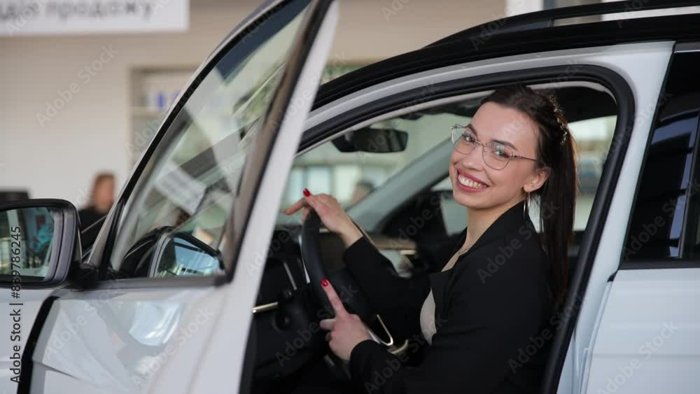 Portrait of a happy smiling business woman sitting in a car with the door open Portrait of a happy smiling business woman sitting in a car with the door open
