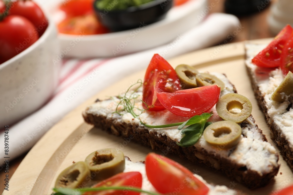 Delicious ricotta bruschettas with fresh tomatoes, olives and greens on table Delicious ricotta bruschettas with fresh tomatoes, olives and greens on table