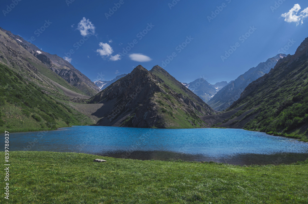 Lake with blue clear clear water in the mountains in summer. Koksai Ainakol Lake in Tien Shan Mountains in Asia in Kazakhstan Lake with blue clear clear water in the mountains in summer. Koksai Ainakol Lake in Tien Shan Mountains in Asia in Kazakhstan