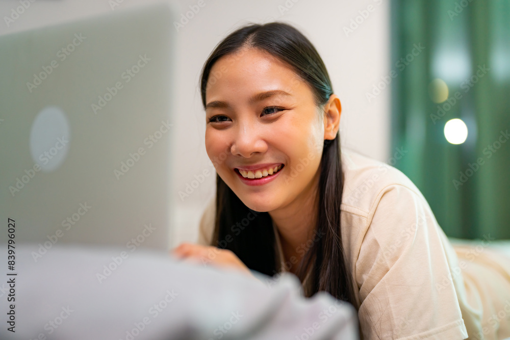 Asian woman freelance working on laptop computer using AI searching data on the bed. Businesswoman remote working online corporate business financial at home. Modern life and technology concept. Asian woman freelance working on laptop computer using AI searching data on the bed. Businesswoman remote working online corporate business financial at home. Modern life and technology concept.