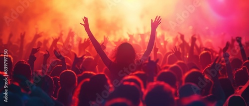 Silhouettes of a crowd at a concert, with arms raised in the air.