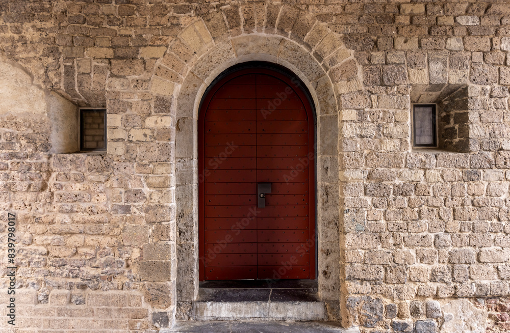 red door with merallic inserts in an old stone castle
red door with merallic inserts in an old stone castle