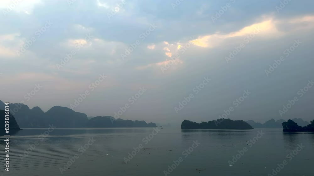 Morning view of the ocean with mountains in the background. Sea views with limestone karst mountains and a cloudy sky. Ha Long Bay, Vietnam. Morning view of the ocean with mountains in the background. Sea views with limestone karst mountains and a cloudy sky. Ha Long Bay, Vietnam.
