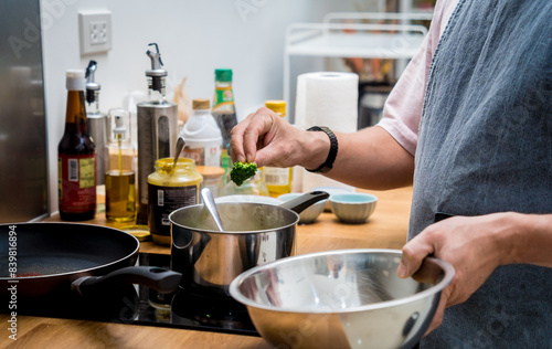 Chef at the kitchen preparing lentils soup with cauliflower and broccoli