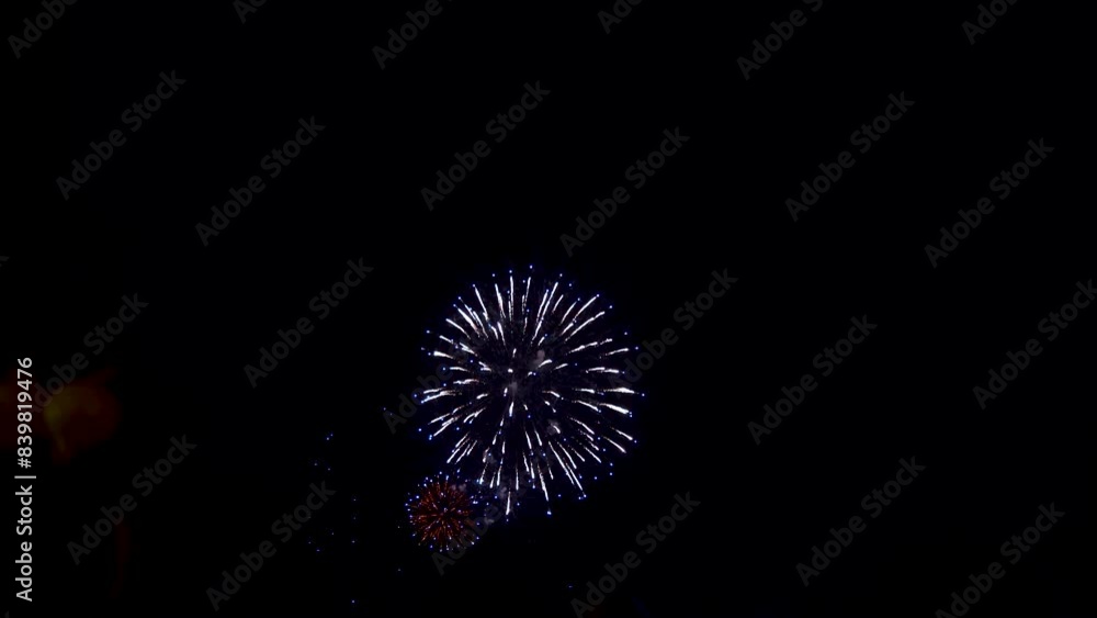 Incredible fireworks display against dark night sky with peoples' silhouettes Incredible fireworks display against dark night sky with peoples' silhouettes