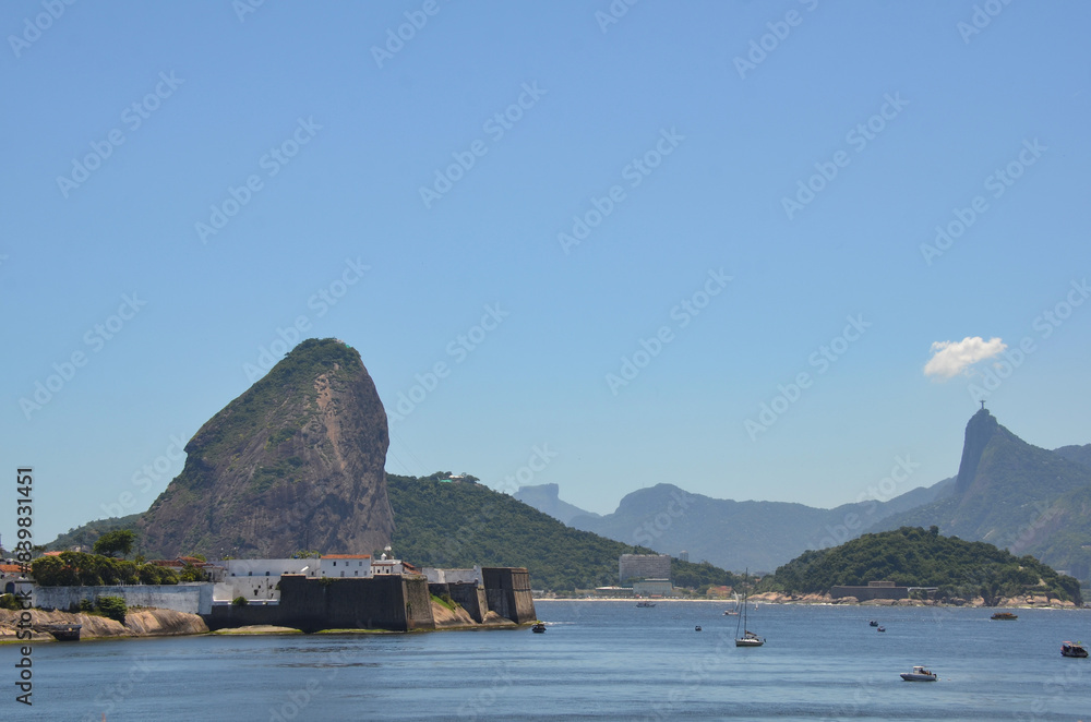 Wide view Fortaleza de Santa Cruz da Barra with the sugar loaf (Pão de Açúcar) in the background from the waterfront of Niterói, Rio de Janeiro Wide view Fortaleza de Santa Cruz da Barra with the sugar loaf (Pão de Açúcar) in the background from the waterfront of Niterói, Rio de Janeiro