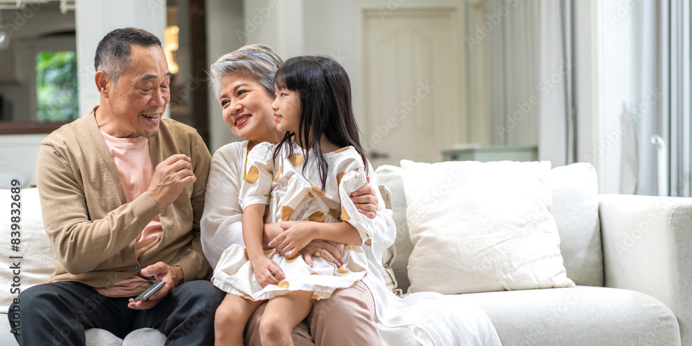 Portrait of happy love asian grandfather with grandmother and asian little cute girl enjoy relax at home.Young girl with their laughing grandparents smiling together.Family and togetherness Portrait of happy love asian grandfather with grandmother and asian little cute girl enjoy relax at home.Young girl with their laughing grandparents smiling together.Family and togetherness