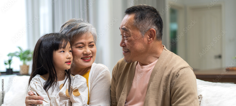Portrait of happy love asian grandfather with grandmother and asian little cute girl enjoy relax at home.Young girl with their laughing grandparents smiling together.Family and togetherness Portrait of happy love asian grandfather with grandmother and asian little cute girl enjoy relax at home.Young girl with their laughing grandparents smiling together.Family and togetherness