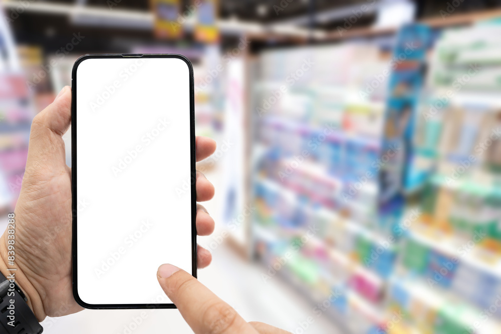 Hand holding blank screen smartphone for copy space on blurred Miscellaneous Product shelf. e-commerce app shopping mockup. social media, payment and shopping online concept. Hand holding blank screen smartphone for copy space on blurred Miscellaneous Product shelf. e-commerce app shopping mockup. social media, payment and shopping online concept.