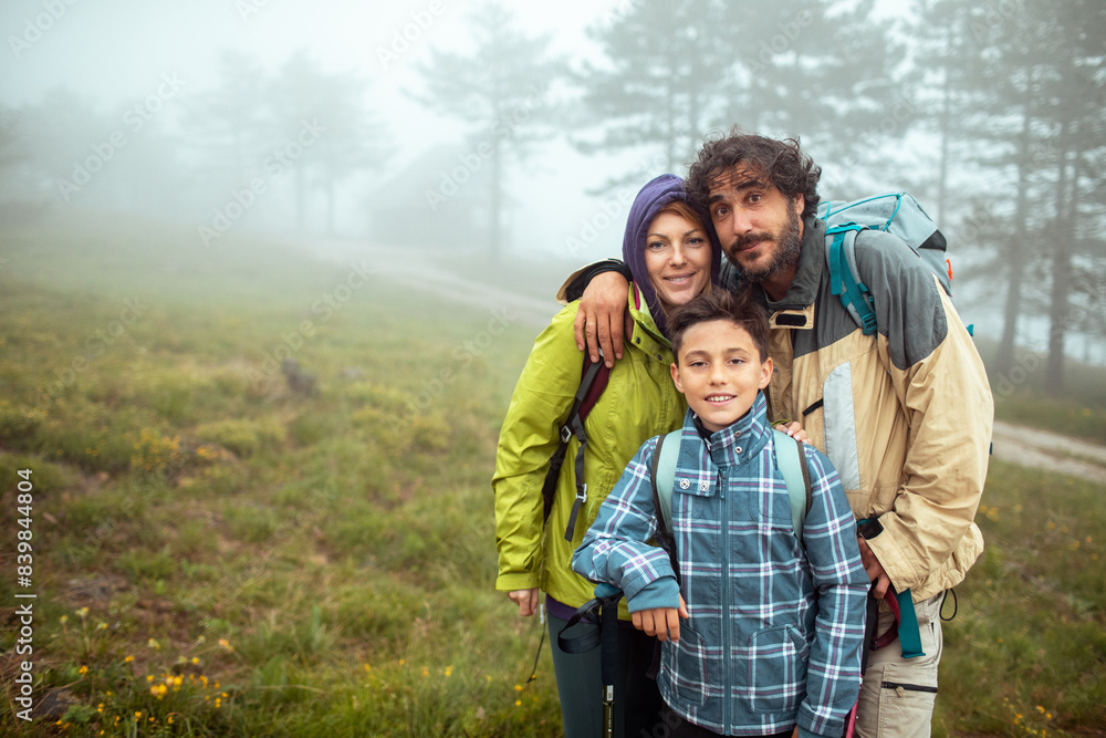 Portrait of a happy family together during a foggy hike in the mountains Portrait of a happy family together during a foggy hike in the mountains