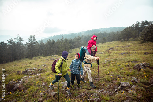 Active family hiking in the mountains with children on a foggy day photo