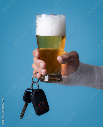 Obraz na płótnie Adult Asian man with gauze bandage wrapped around his injured arms holding glass of alcoholic drink with car keys, closeup