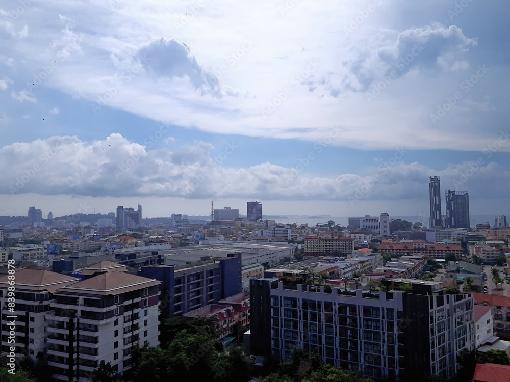Obraz premium Cityscape with ocean view under cloudy sky