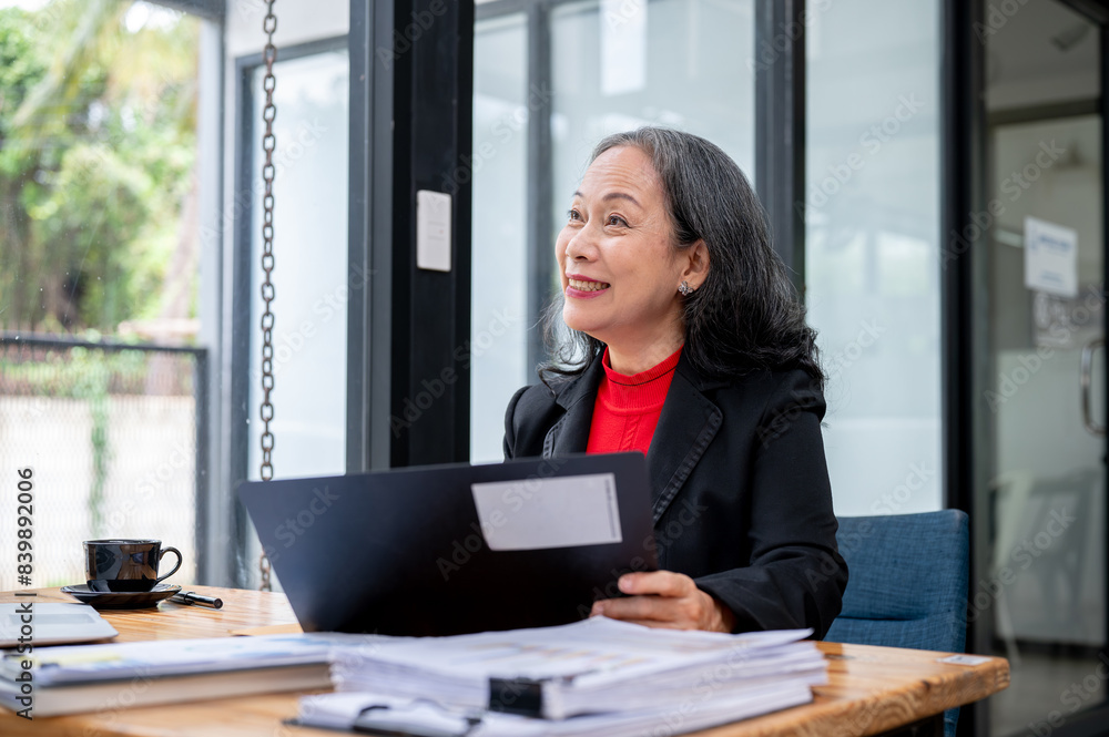 A mature Asian businesswoman is interviewing a candidate or having a meeting with her employee. A mature Asian businesswoman is interviewing a candidate or having a meeting with her employee.