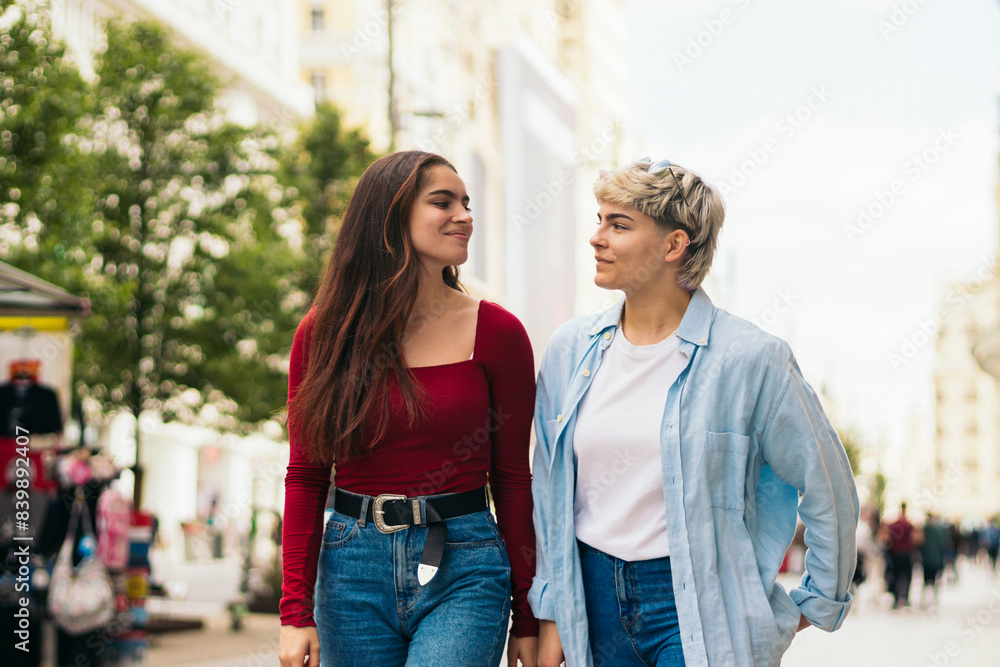 Fototapeta premium two teenager girls walking and talking in a city street
