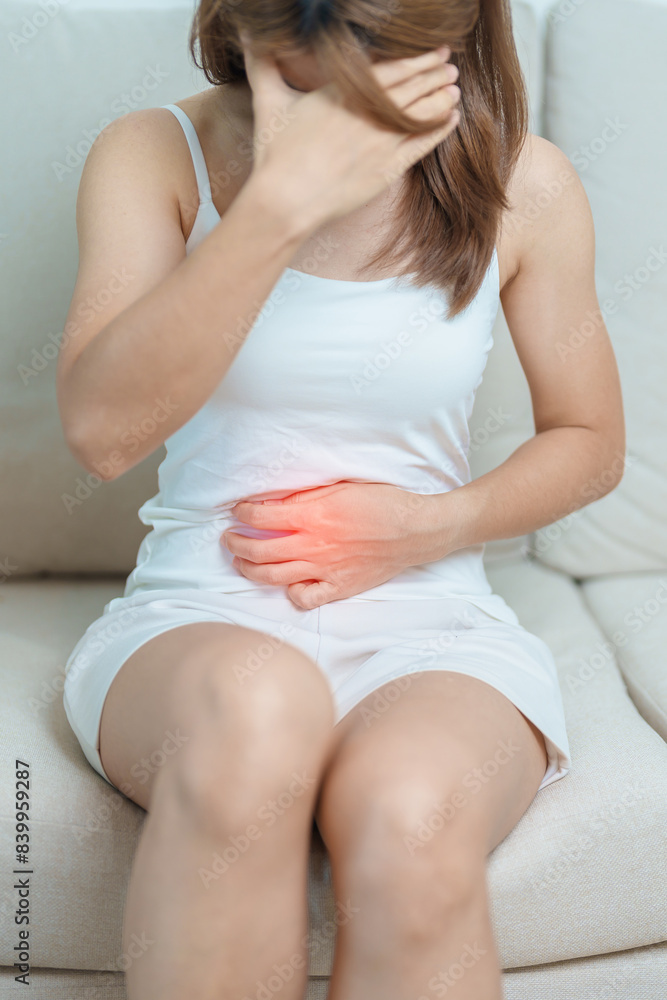 woman having abdomen ache due to Stomach pain, digestion with constipation or Diarrhea from food poisoning, female problem and Endometriosis, Hysterectomy, Stomachache and Menstrual on sofa at home woman having abdomen ache due to Stomach pain, digestion with constipation or Diarrhea from food poisoning, female problem and Endometriosis, Hysterectomy, Stomachache and Menstrual on sofa at home