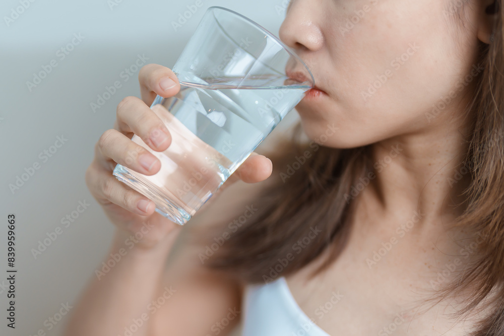 Happy woman holding water glass, female drinking pure water on sofa at home. Healthy, Refreshment, lifestyle and daily routine concept Happy woman holding water glass, female drinking pure water on sofa at home. Healthy, Refreshment, lifestyle and daily routine concept