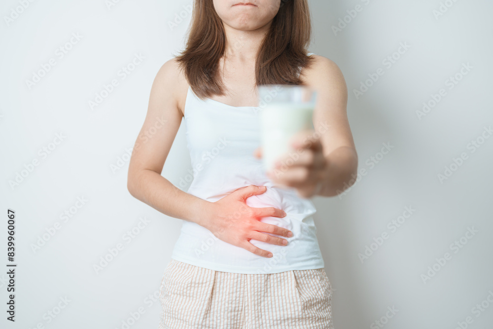 Lactose intolerance and Milk allergy concept. woman hold Milk glass and having abdominal cramps and pain when drink Cow Milk. Symptom stomach ache, Dairy intolerant, Nausea, Bloating, Gas and Diarrhea Lactose intolerance and Milk allergy concept. woman hold Milk glass and having abdominal cramps and pain when drink Cow Milk. Symptom stomach ache, Dairy intolerant, Nausea, Bloating, Gas and Diarrhea