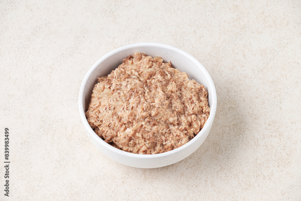 Wet cat food in a white cup on white background. Wet cat food in a white cup on white background.
