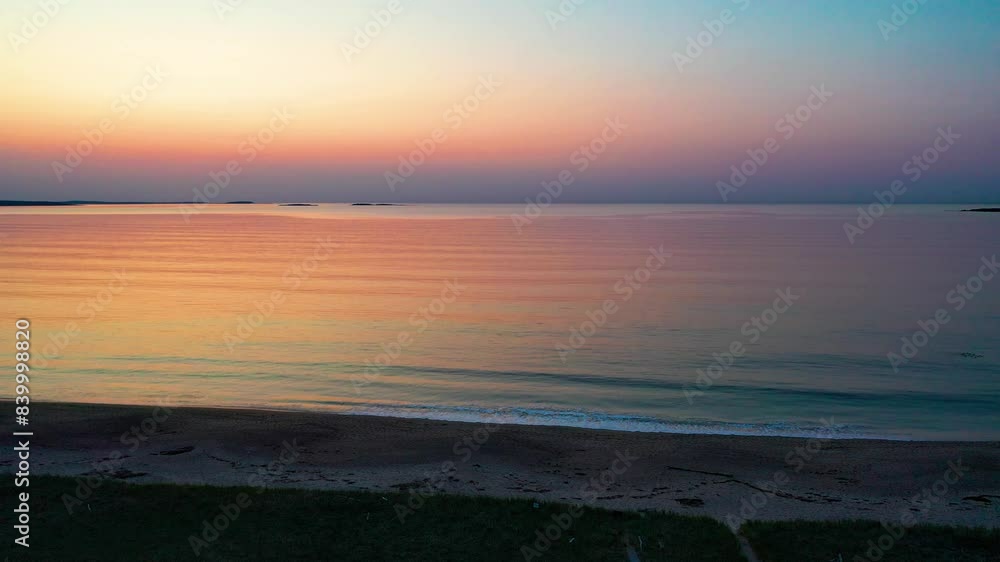 Wooden Walking Path Leads to Colorful Beach Sunrise With Ocean Waves. Aerial Drone Lowering Through Trees onto Grass at Dawn with Beautiful Red Orange and Purple Colors in Sky and Reflecting off Water Wooden Walking Path Leads to Colorful Beach Sunrise With Ocean Waves. Aerial Drone Lowering Through Trees onto Grass at Dawn with Beautiful Red Orange and Purple Colors in Sky and Reflecting off Water