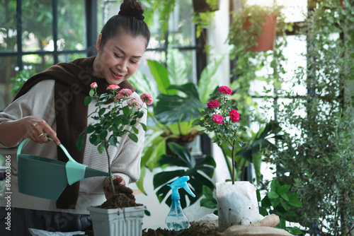 Middle-aged woman spent the holiday taking care of the indoor green house, happy woman loves plants and flowers enjoy leisure activities in the relaxing green house