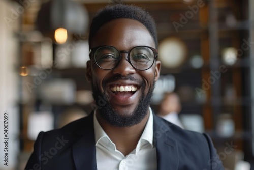 Man smiling, wearing glasses and white shirt at eatery