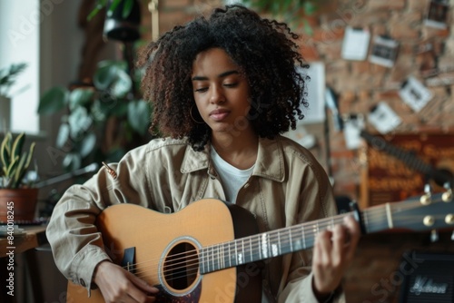 Female musician strumming guitar indoors