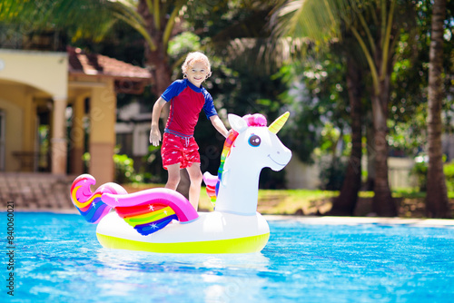 Child on unicorn float in swimming pool. Kids swim © famveldman