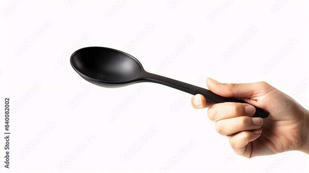 Image of a person's hand grasping a synthetic stew spoon on a separate blank surface Image of a person's hand grasping a synthetic stew spoon on a separate blank surface